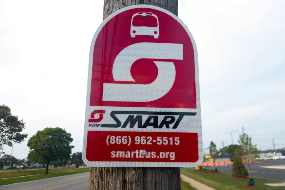 A sign for SMART Bus on a pole.